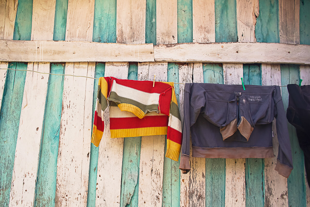 Clothes hung out to dry on a line against a candy-striped wall