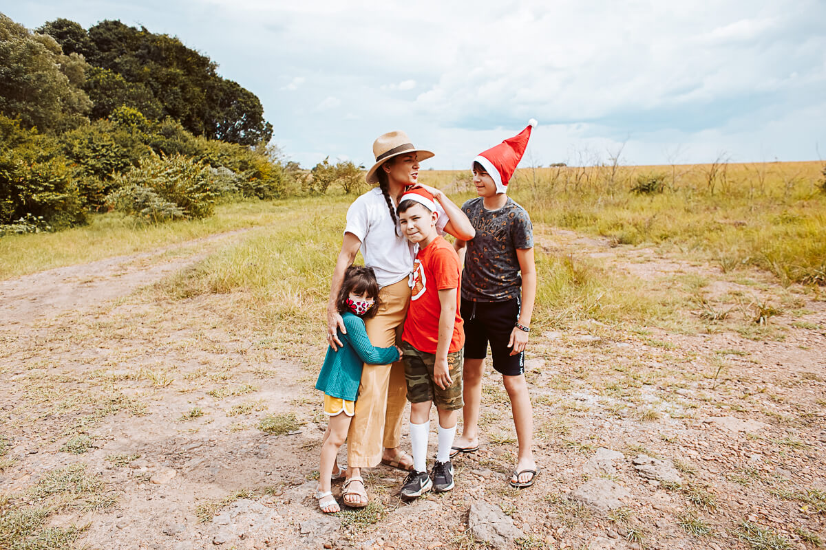 Long Miles co-founder, Kristy Carlson, standing with her three children huddled together in the middle of a field. 