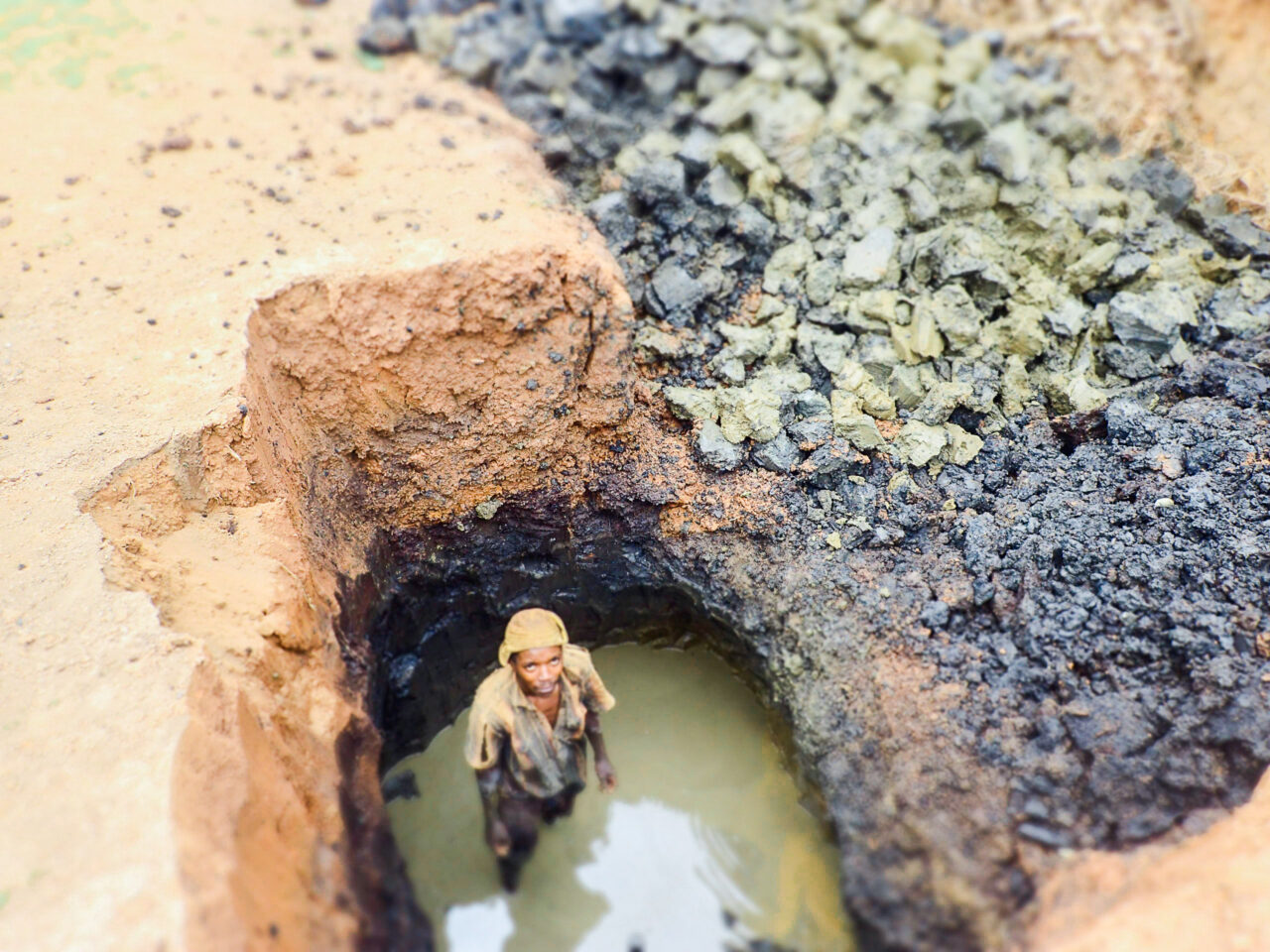 A Burundian brick-maker looking for clay to make bricks