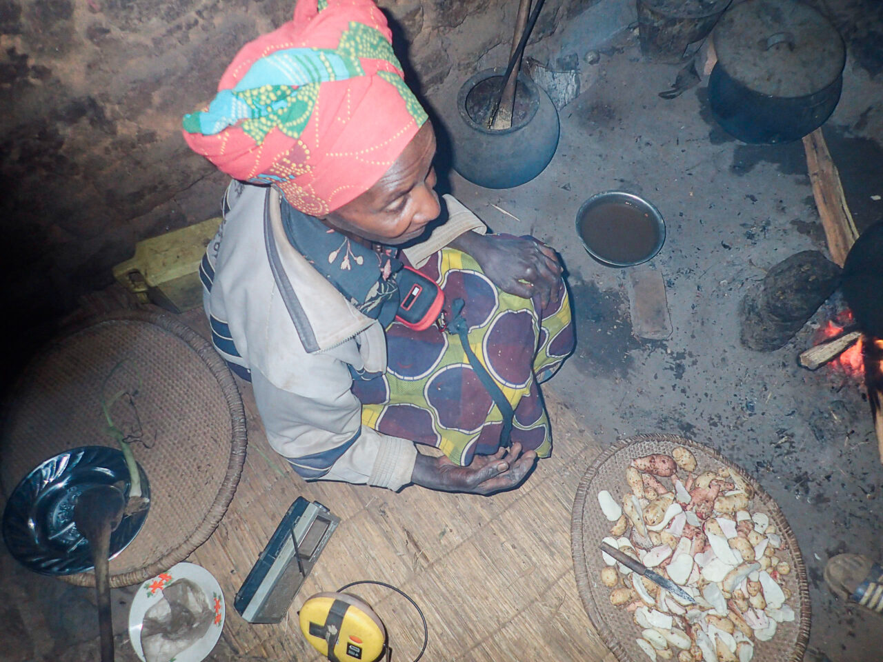 Mama Claude, a Burundian coffee farmer, cooking over a wood-fired stove in her home